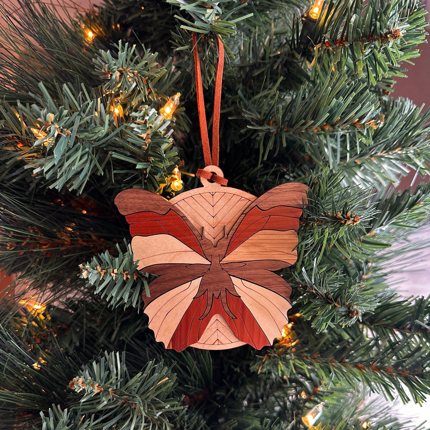 Layered wooden butterfly ornament made with multiple species of wood.