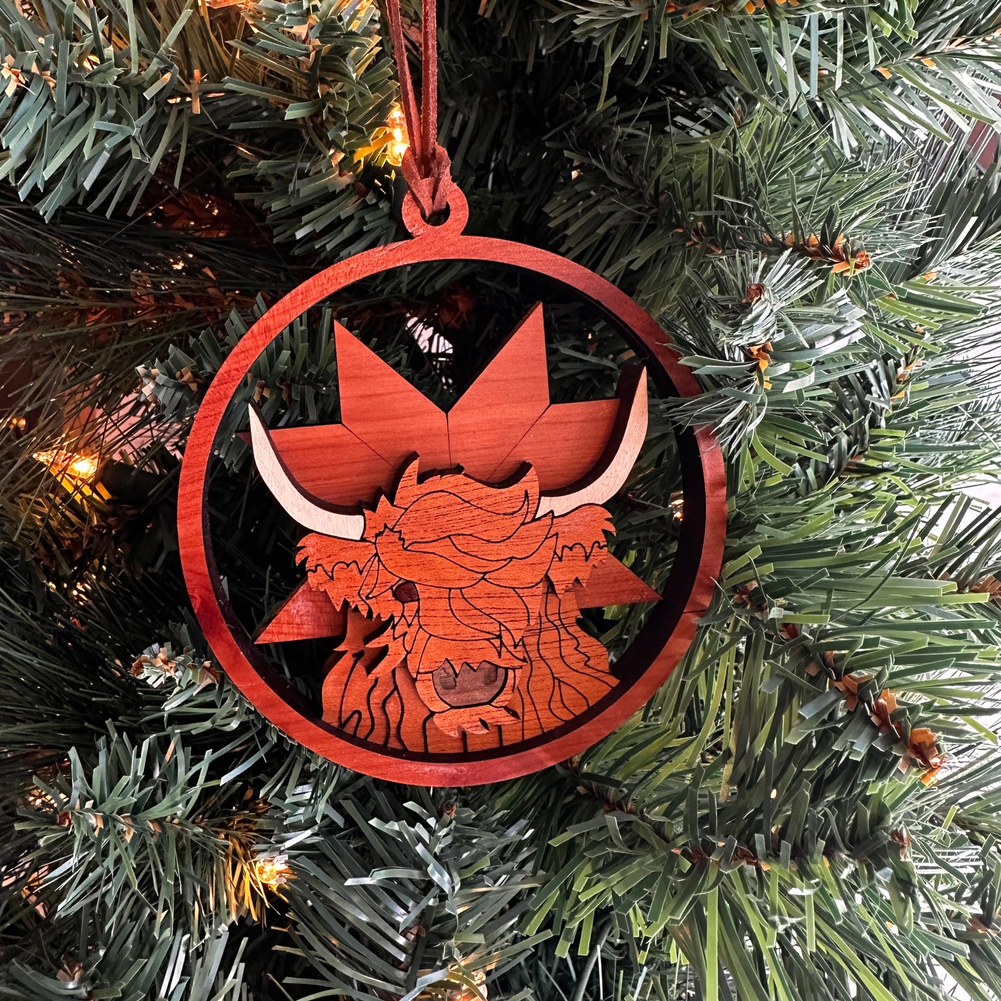Layered wooden highland cow ornament made with multiple species of wood.